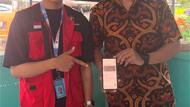 Sulhan (kiri), kreator rUang Tani sekaligus mahasiswa KKN Tematik Unhas, menunjukkan antarmuka aplikasi pembukuan yang telah berhasil diakses melalui gawai salah satu peserta (kanan). Momen ini diabadikan usai kegiatan peluncuran dan pelatihan aplikasi di Kelurahan Banyorang, Kec. Tompobulu, Kab. Bantaeng. (Foto: Dok. Pribadi)