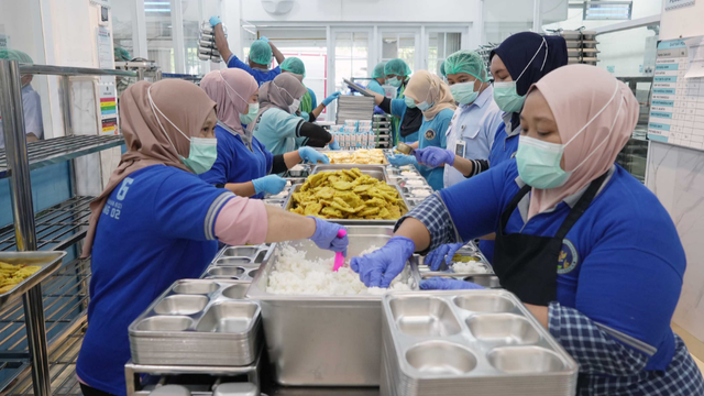Petugas menyiapkan paket Makan Bergizi Gratis (MBG) di dapur produksi sebelum didistribusikan kepada para penerima manfaat. Di balik setiap porsi makanan, tata kelola yang efektif menjadi faktor utama untuk memastikan program berjalan tepat sasaran, berkualitas, dan berkelanjutan. (Foto: Dok. BGN)