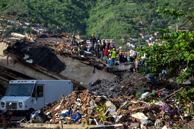 Tim penyelamat dan sukarelawan membantu menemukan korban selamat di reruntuhan bangunan yang runtuh di Caraballeda, negara bagian La Guaira, Venezuela, Kamis (30/7/2026). Foto: Miguel Medina/AFP
