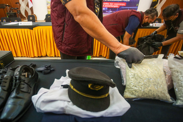 Petugas Bea Cukai Indonesia bersiap memamerkan seragam pilot Malaysia dan narkoba yang diselundupkannya sebagai barang bukti sebelum konferensi pers di Bandara Internasional Soekarno-Hatta di Tangerang, Jumat (31/7/2026). Foto: RAMU/AFP