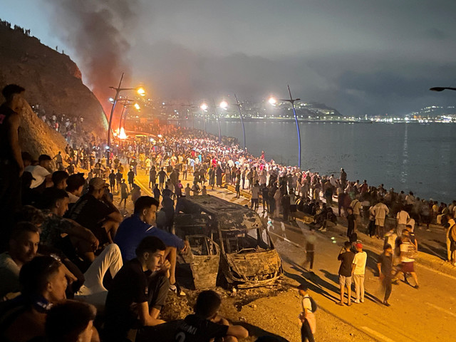 Para migran berkumpul di sekitar kendaraan yang dibakar sambil menunggu kesempatan untuk menyeberang ke wilayah kantong Spanyol di Ceuta, di sisi perbatasan Maroko di Fnideq, Maroko, Jumat (31/7/2026). Foto: Ahmed El Jechtimi/Reuters