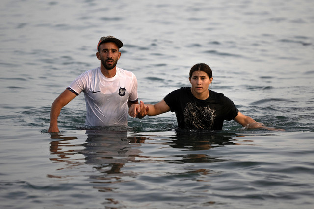 Para migran menyeberangi air di dekat perbatasan dengan Maroko saat mereka mencoba memasuki wilayah kantong Spanyol di Afrika Utara, Ceuta, Spanyol, Jumat (31/7/2026). Foto: Jorge Guerrero/AFP