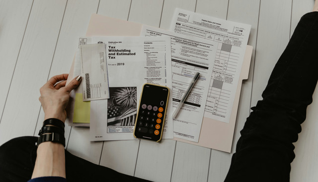 Ilustrasi seseorang menyusun anggaran keuangan pribadi sebagai bagian dari pengelolaan finansial yang lebih bijaksana. Sumber: Unsplash.