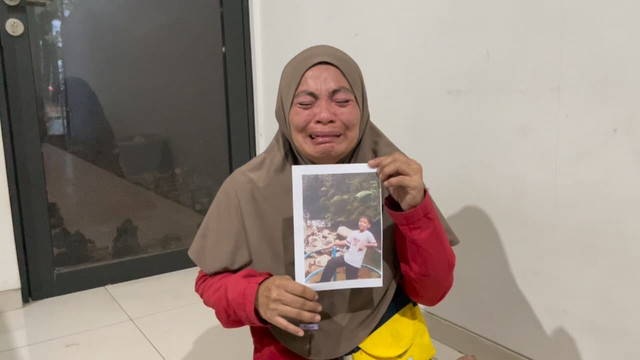 Seorang ibu bernama Nurjanah menangis histeris saat melaporkan anaknya yang hilang di pos polisi kawasan Graha Bunga, Kecamatan Pondok Aren, Kota Tangerang Selatan, Selasa (4/8). Foto: Dok. Istimewa