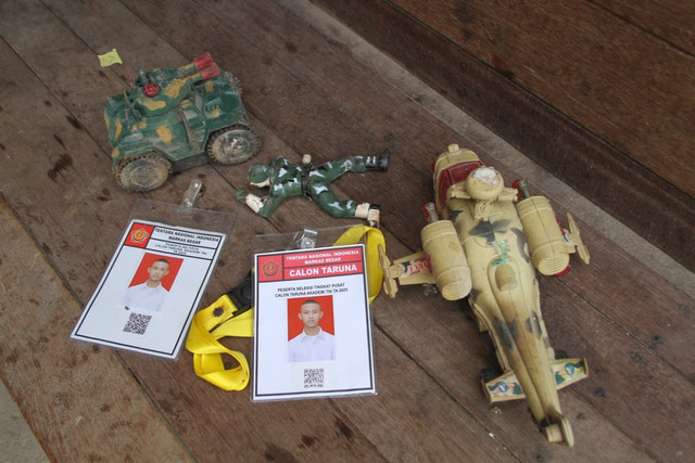M Jasmin dan Suparsih menunjukkan mainan motif tentara milik Fauzan semasa kecil yang masih disimpan, Selasa (4/8/2026). Foto: Vega Maarijil Ula/kumparan