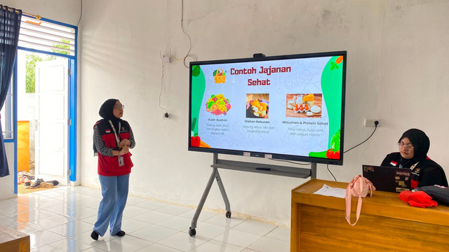 Mahasiswa KKN Unhas Gelombang 116, Aqilah, mempresentasikan panduan 'Contoh Jajanan Sehat' dalam program edukasi gizi bagi siswa SD Inpres Layoa, Desa Bajiminasa, Bantaeng, Kamis (23/07/2026).