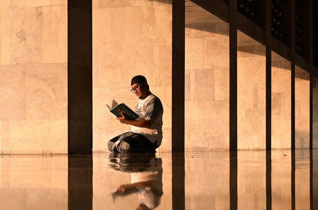 Seseorang sedang membaca Al Quran foto by Pexels