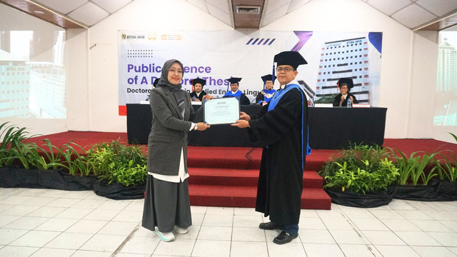 Momen penyerahan sertifikat kepada Hayati usai sidang terbuka disertasi (Sumber: Unika Atma Jaya)
