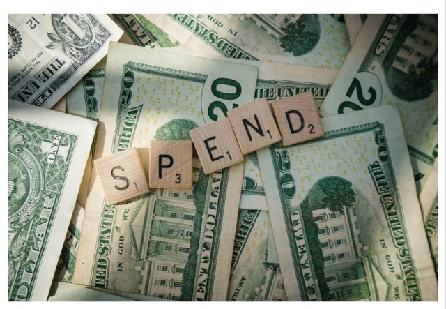 Ilustrasi bertuliskan "Spend" dengan elemen uang yang merepresentasikan aktivitas pengeluaran dalam kehidupan sehari-hari. Sumber: Unsplash.