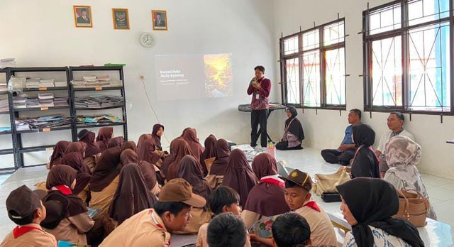 Ketua KKN memberikan sambutan di depan siswa dan guru.