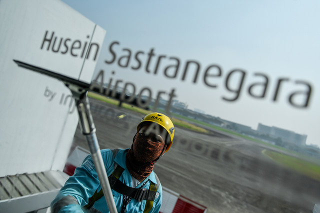 Petugas membersihkan kaca ruang tunggu di Bandara Husein Sastranegara, Bandung, Jawa Barat, Jumat (7/8/2025). Foto: ANTARA FOTO/Raisan Al Farisi