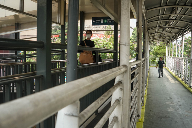 Sejumlah warga berjalan melintasi Jembatan Penyebrangan Orang (JPO) Rasuna Said, Jakarta, Minggu (9/8/2026). Foto: Iqbl Firdaus/kumparan