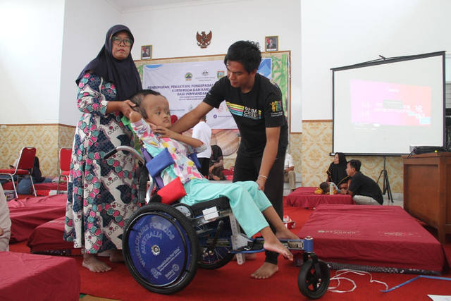 Fitriana, remaja pengidap hidrosefalus saat mengikuti acara pengukuran kursi roda adaptif di aula Kantor Kecamatan Kota, Kabupaten Kudus, Jawa Tengah pada Senin (10/8). Foto: Vega Ma'arijil Ula/kumparan