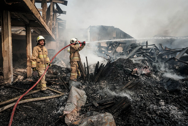 Petugas Dinas Penanggulangan Kebakaran dan Penyelamatan (Gulkarmat) Jakarta melakukan pendinginan di area pabrik bingkai yang terbakar di kawasan Pondok Kelapa, Duren Sawit, Jakarta, Rabu (12/8/2026). Foto: Iqbal Firdaus/kumparan