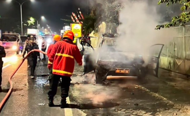 Petugas pemadam kebakaran bantu padamkan mobil polisi yang terbakar di Pasuruan. Foto: Dok. Istimewa