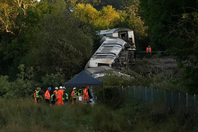 Gerbong kereta yang tergelincir di dekat kota Lewes, Inggris, Kamis (13/8). Foto: Carlos Jasso/AFP