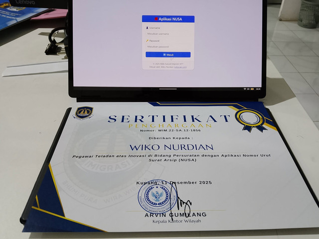 Sertifikat penghargaan Pegawai Teladan yang disandingkan dengan antarmuka aplikasi NUSA (Nomor Urut Surat Arsip) pada layar kerja. (Foto: Dok. Pribadi)