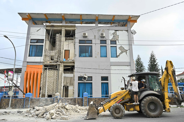 Sejumlah pekerja mengamati kondisi bangunan Bank NTT Kantor Cabang Ruteng yang mengalami kerusakan akibat gempa di Kabupaten Manggarai, NTT, Minggu (16/8/2026). Foto: Fikri Yusuf/ANTARA FOTO