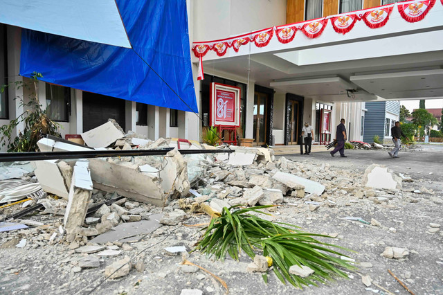 Pekerja berjalan di dekat bangunan Kantor Bupati Manggarai yang mengalami kerusakan akibat gempa di Kabupaten Manggarai, NTT, Minggu (16/8/2026).  Foto: Fikri Yusuf/ANTARA FOTO