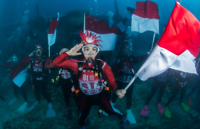 Ketua Wanita Selam Indonesia (WASI) Tri Tito Karnavian bersama Bupati Biak Numfor Markus Mansnembra serta para pengurus WASI dan penyelam setempat melaksanakan upacara dan parade bendera Merah Putih di bawah laut Pulau Biak, Papua. Foto: Dok. Kemendagri