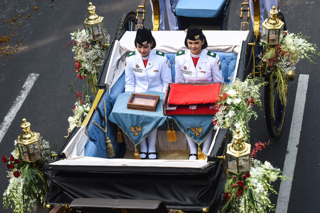 Purna Paskibraka Duta Pancasila 2025 Bianca Sultana Najwa (kanan) dan Aliah Sakira (kiri) membawa bendera pusaka dan naskah Proklamasi di atas kereta kencana Garuda Prabayaksa dari Monas menuju Istana Merdeka, Senin (17/8/2026). Foto: M Risyal Hidayat/ANTARA FOTO