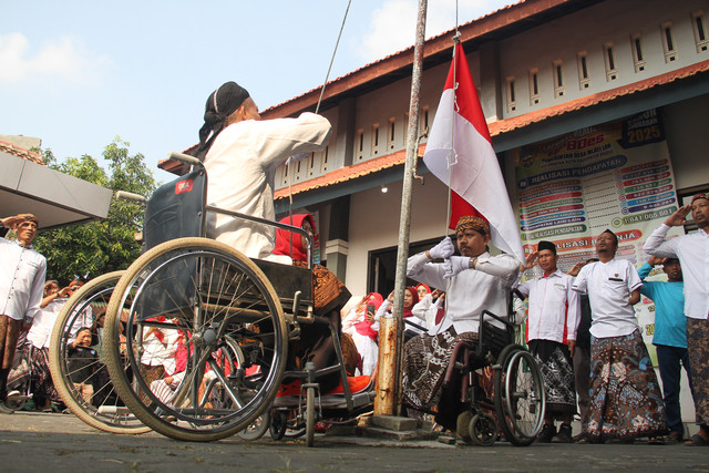 Disabilitas mengibarkan bendera merah putih saat peringatan Hari Ulang Tahun ke-81 Republik Indonesia di halaman kantor Balai Desa Mlati Lor, Kabupaten Kudus, Jawa Tengah, pada Senin (17/8/2026). Foto: Vega Ma'arijil Ula/kumparan