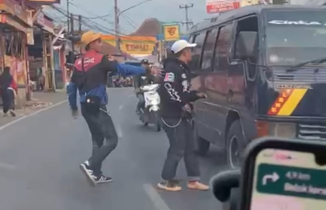 Pemuda berinisial YM (20) membawa golok di tengah Jalan Raya Banjaran-Pangalengan, Kabupaten Bandung, Minggu (16/8/2026). Foto: Dok. Istimewa