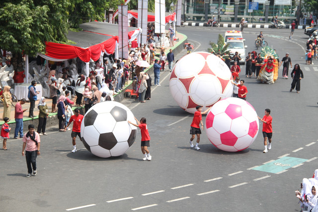 Bola berukuran raksasa ikut memeriahkan kirab atau devile Srikandi Merdeka Cup 2026 dari Alun-alun Simpang Tujuh Kudus, Jawa Tengah menuju finish di Supersoccer Arena, Kudus, pada Senin (17/8/2026) siang. Foto: Vega Ma'arijil Ula/kumparan