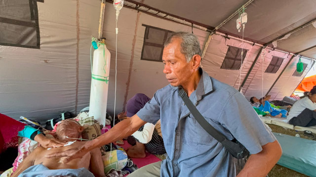 Ibu Siti dan Abdul Manan bercerita soal ayahnya Muhammad Damin yang tertimpa reruntuhan batako saat rumahnya hancur karena gempa saat ditemu di pengungsian Reo, Manggarai, NTT, Senin (17/8/2026). Foto: Rayyan Farhansyah/kumparan