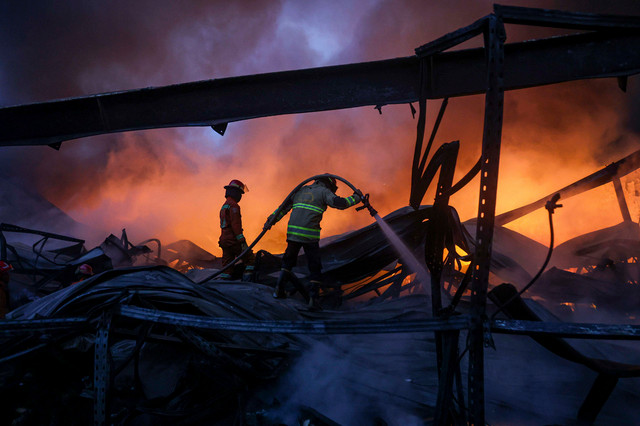 Dua petugas pemadam kebakaran Kota Bekasi berusaha memdamkan api yang membakar sebuah gudang di Bekasi Utara, Kota Bekasi, Jawa Barat, Senin (17/8/2026). Foto: Darryl Ramadhan/ANTARA FOTO