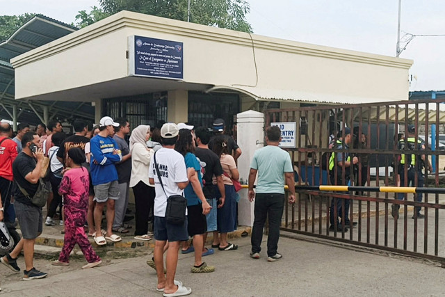 Orang-orang berdiri di luar Universitas Ateneo de Zamboanga setelah penembakan di Zamboanga, Filipina, Selasa (18/8/2026). Foto: Nonoy Lacson/REUTERS