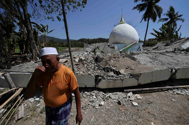 Imam Masjid Babussalam Haji Salahuddin (63) berjalan di dekat lokasi masjid yang roboh akibat gempa di Desa Salamah, Reok, Kabupaten Manggarai, Nusa Tenggara Timur, Selasa (18/8/2026). Foto: Willy Kurniawan/REUTERS
