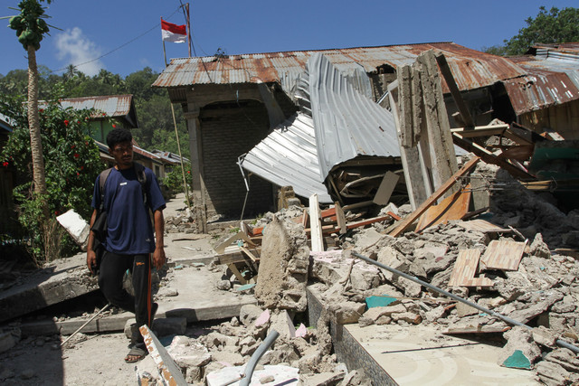 Warga melintas di samping bangunan rumah yang roboh akibat gempa bumi magnitudo 7,7 di Pulau Palue, Kabupaten Sikka, NTT, Rabu (19/8/2026). Foto: Mega Tokan/ANTARA FOTO