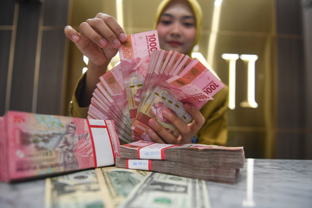 Petugas menunjukkan pecahan mata uang Rupiah dan Dolar AS di Kantor Cabang BNI Pasar Baru, Jakarta, Kamis (20/8/2026). Foto: Muhammad Adimaja/ANTARA FOTO
