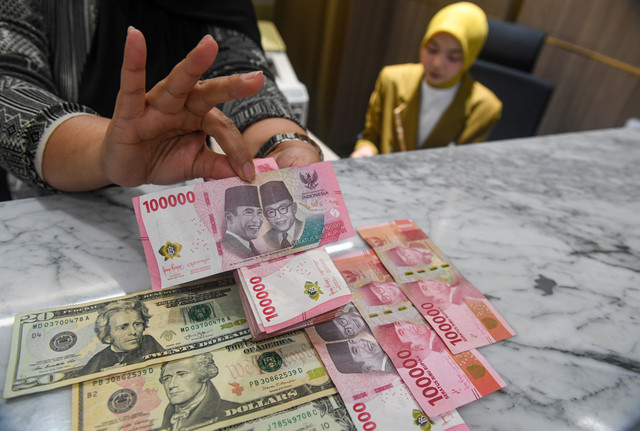 Petugas menunjukkan pecahan mata uang Rupiah dan Dolar AS di Kantor Cabang BNI Pasar Baru, Jakarta, Kamis (20/8/2026). Foto: Muhammad Adimaja/ANTARA FOTO