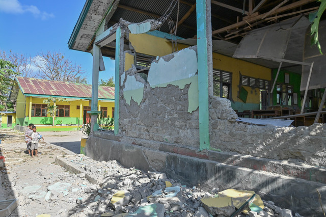 Dua orang anak mengamati bangunan Madrasah Ibtidaiyah Negeri (MIN) 1 Manggarai yang mengalami kerusakan akibat gempa bumi di kawasan Reo, Kabupaten Manggarai, NTT, Kamis (20/8/2026). Foto: Fikri Yusuf/ANTARA FOTO