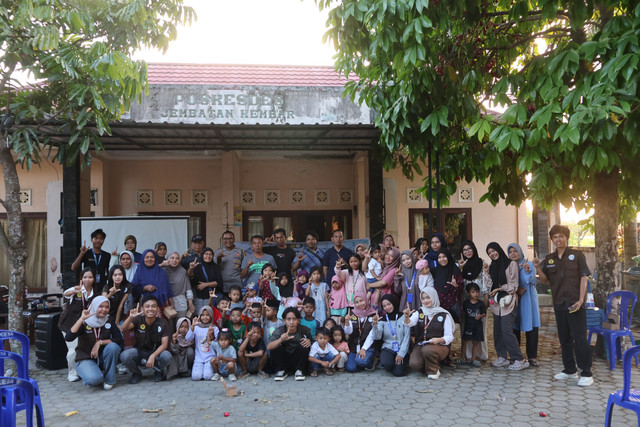 Tim Mahasiswa KKN PMD Universitas Mataram berfoto bersama Sekretaris Desa, Bhabinkamtibmas, tokoh masyarakat, serta warga Desa Jembatan Kembar di depan Poskesdes usai kegiatan sosialisasi. (Sumber Foto: Dokumentasi Pribadi)