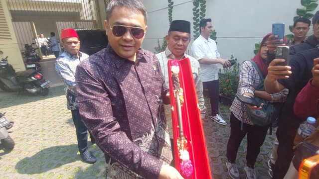 Anggota DPD RI perwakilan Provinsi Bali, Arya Widakarna, memberikan tongkat Ganesha Bali kepada Presiden ke-7 RI Joko Widodo (Jokowi), Jumat (21/8). Dok kumparan