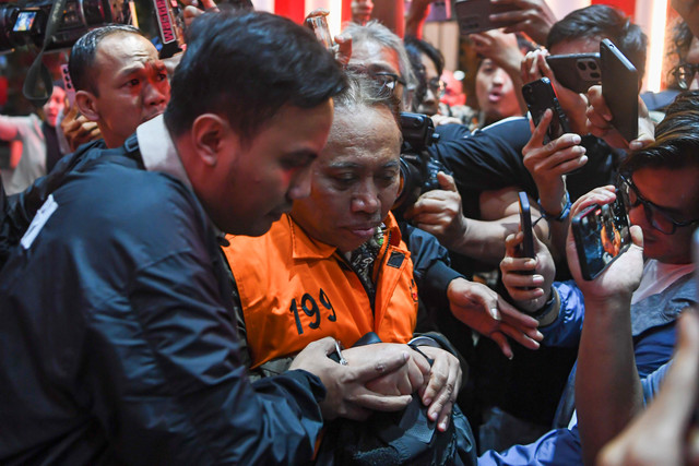 Rektor Universitas Jenderal Soedirman (Unsoed) Akhmad Sodiq (kedua kiri) berjalan menuju mobil tahanan seusai menjalani pemeriksaan di Gedung Merah Putih KPK, Jakarta, Sabtu (22/8/2026). Foto: M Risyal Hidayat/ANTARA FOTO