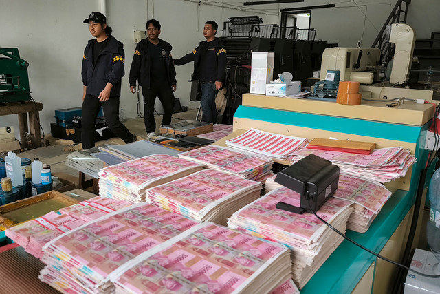Petugas kepolisian berada di dekat tumpukan uang palsu saat melakukan penggerebekan di Taman Tekno Bumi Serpong Damai (BSD), Serpong, Tangerang Selatan, Banten, Sabtu (22/8/2026). Foto: Muhammad Iqbal/ANTARA FOTO