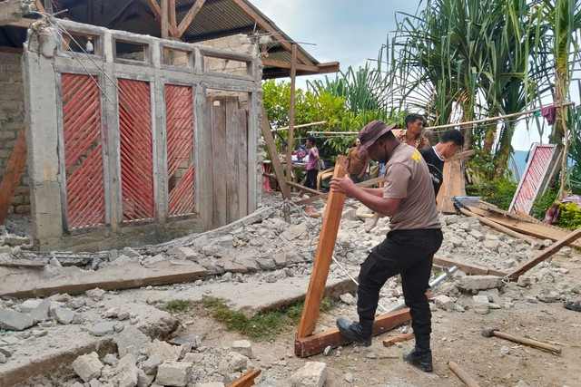 Polisi membantu bersihkan material rumah yang rusak usai gempa di Desa Cibal Barat, Manggarai, NTT, Sabtu (22/8/2026). Foto: Polda NTT
