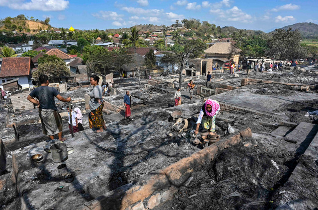Warga mengais puing sisa barang-barang mereka yang terbakar di Desa Adat Sade, Rembitan, Kecamatan Pujut, Praya, Lombok Tengah, NTB, Minggu (23/8/2026). Foto: Ahmad Subaidi/ANTARA FOTO