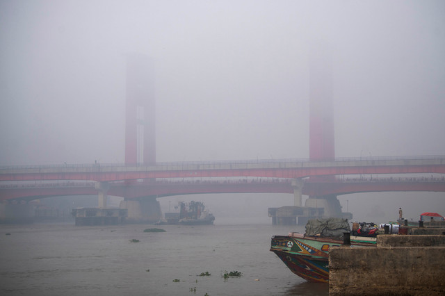 Warga berada di atas perahu tradisional dengan latar belakang jembatan Ampera Palembang yang tertutup kabut asap di kawasan 16 ilir Palembang, Sumatera Selatan, Minggu (23/8/2026). Foto: Nova Wahyudi/ANTARA FOTO