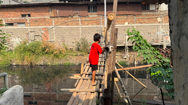 Jembatan bambu menjadi akses sementara warga di RT 05/RW 02, Jalan Warung Pojok, Gang Perkutut, Kelurahan Tegal Alur, Kecamatan Kalideres, Jakarta Barat, Selasa (25/8/2026). Foto: Zahira Hilman/kumparan