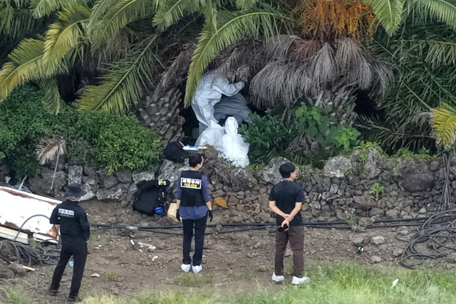 Petugas kepolisian berada di lokasi perkebunan pohon palem tempat jenazah orang hilang bernama Jang Mi-ran ditemukan di Pulau Jeju, Korea Selatan, Senin (24/8/2026). Foto: Yonhap via REUTERS