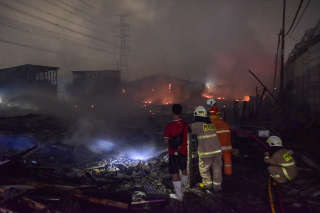 Petugas Suku Dinas Penanggulangan Kebakaran dan Penyelamatan (Sudin Gulkarmat) melakukan pendinginan saat kebakaran rumah semi permanen di Muara Angke, Jakarta, Rabu (26/8/2026). Foto: Fakhri Hermansyah/ANTARA FOTO
