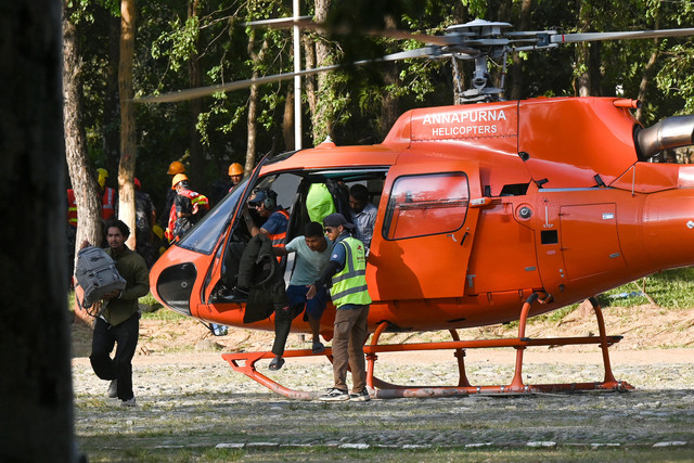 Warga dievakuasi menggunakan helikopter di sebuah kamp militer setelah banjir bandang, di kota Battar Bazar, distrik Nuwakot, Nepal, pada 27 Agustus 2026. Foto: Prakash Mathema / AFP