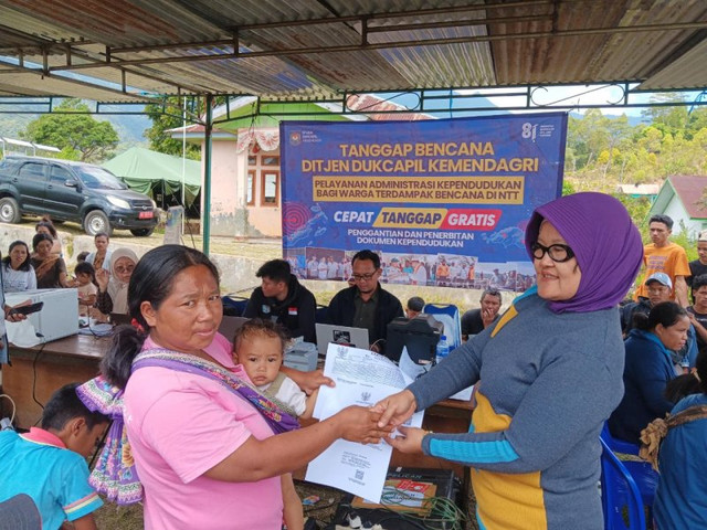 Direktur IDKN Ditjen Dukcapil Handayani Ningrum menyerahkan dokumen kependudukan kepada warga Desa Longko, Manggarai, NTT, dalam aksi tanggap bencana yang mencatat 758 layanan adminduk selama tiga hari. Foto: Dok. Istimewa