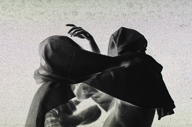 Artistic black and white photo of two hooded figures in motion, creating a textured visual effect. Foto: Mariana Montrazi/Pexels.