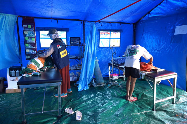 Tim Medis Darurat (Emergency Medical Team/EMT) Muhammadiyah sedang melayani kesehatan penyintas di RS Lapangan, Dampek. 